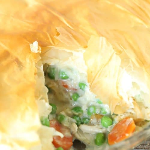 Pie dish with a lighter chicken pot pie inside.
