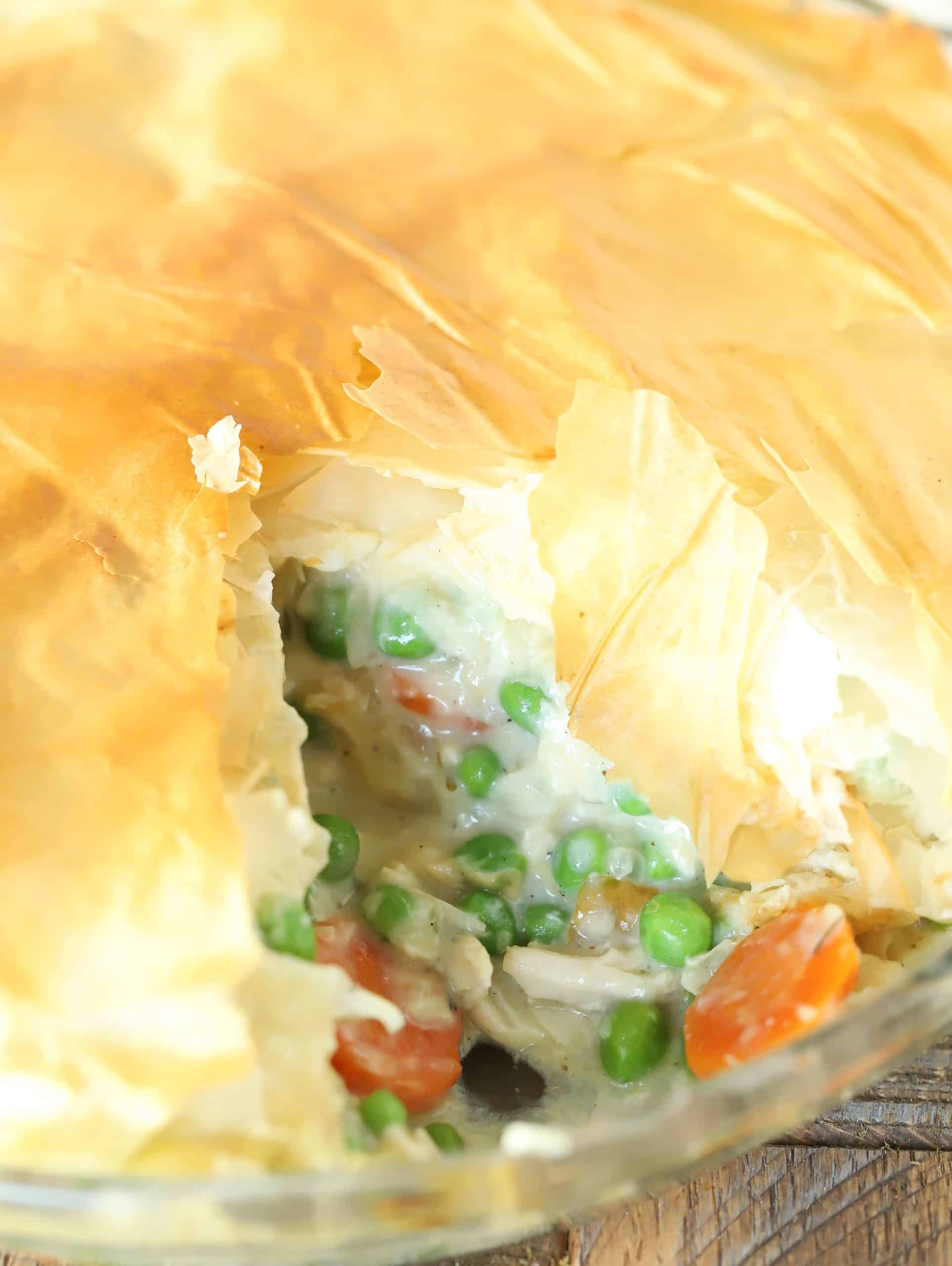 Pie dish with a lighter chicken pot pie inside.