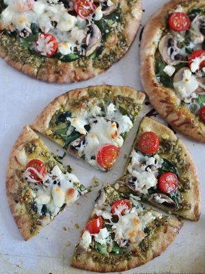 These Easy Pesto Pita Bread Pizzas use pita bread as the crusts and are spread with pesto and topped with veggies. Delicious and healthy lunch, dinner or snack!