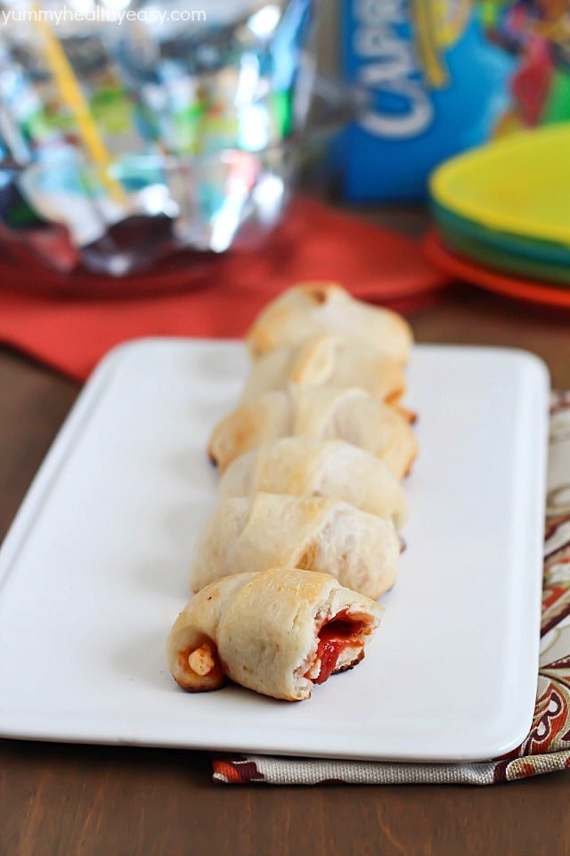 Simple & delicious Pizza Rolls made from ready-made pizza dough, mozzarella sticks, pizza sauce and pepperoni all rolled together in a fun little bite and served with a refreshing Capri Sun! #ad