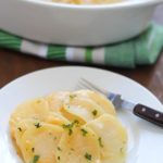 Cheesy Potatoes au Gratin made with a homemade cheese sauce drizzled over thinly sliced potatoes and a layer of onions nestled in the middle. A great Thanksgiving recipe! Plus a full blog hop Thanksgiving menu to help plan your turkey day meal!