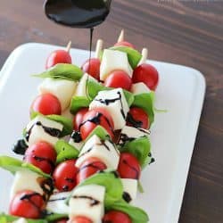 Summer afternoons call for these fun Caprese Skewers! Cherry tomatoes, fresh basil and cubes of mozzarella cheese threaded on skewers and drizzled with an easy balsamic reduction. Delicious!