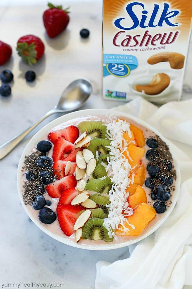 This Tropical Smoothie Bowl Recipe is the perfect breakfast or snack! It's dairy-free, gluten-free, full of protein and fresh fruit and totally delicious. Satisfying and easy to make, too! #SilkCashew #ad