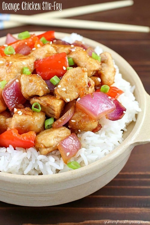 The most incredible Orange Chicken Stir Fry with pan seared, bite-sized chicken, red bell peppers, onion and a delicious sweet and savory sauce served over rice. #dinner #easydinner #orangechicken via @jennikolaus