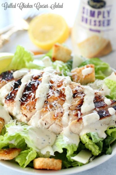Grilled Chicken Caesar Salad for a yummy summertime lunch or dinner! With a simple yogurt marinade recipe, this grilled chicken is tender and delicious. Served over romaine lettuce, homemade croutons, shaved parmesan and caesar dressing - YUM!!