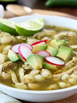 This Chicken Posole Verde Recipe has shredded chicken and tender hominy in a crazy flavorful verde broth! Such wonderful flavor in the verde sauce, you won't even believe it! This soup is best served with radishes, cilantro, avocado, queso fresco and/or tortilla chips. (Skip the chips to keep this gluten free!) AD