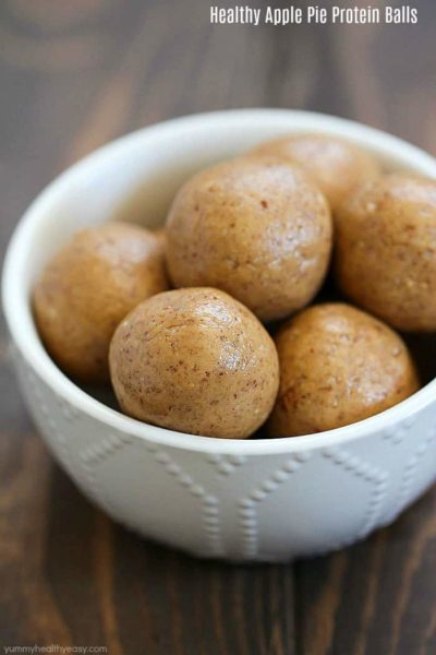 Small white bowl filled with Healthy Apple Pie Protein Balls.