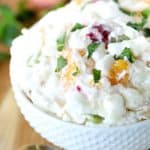 Square image - White bowl filled with fruit salad.