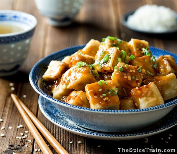 Sesame Tofu in a blue bowl with chopsticks on the side.