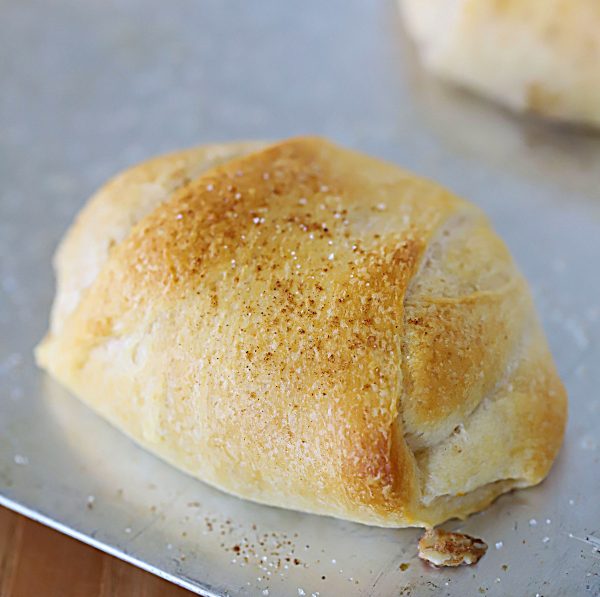 Close up of a peach rollup on a baking sheet, straight from the oven.