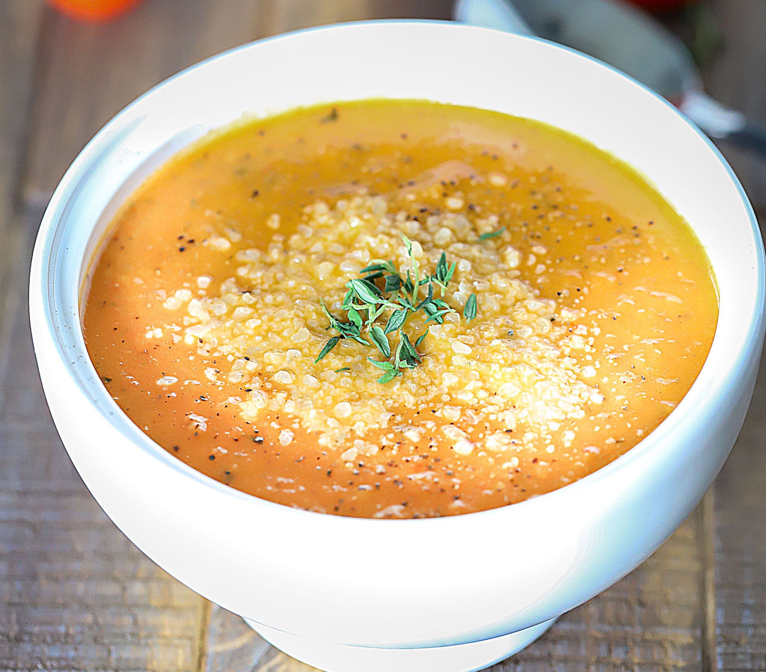 Bowl of soup topped with herbs.